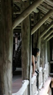Elegant Asian Girl in Traditional Wooden Pavilion Phone Wallpaper