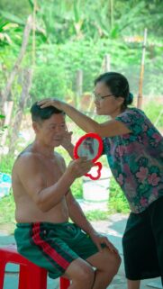 Elderly Couple Sharing A Heartfelt Haircut Moment Mobile Wallpaper