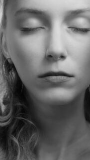 Serene Close-up Portrait of Woman with Closed Eyes Mobile Wallpaper