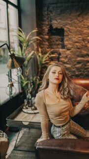 Chic Blonde Woman in Cozy Cafe Portrait Mobile Wallpaper