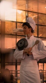 Young Chef Holding Pan and Wooden Spoon Aesthetic Phone Wallpaper