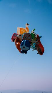 Cheerful Bunch of Colorful Character Balloons Floating in the Sky Wallpaper
