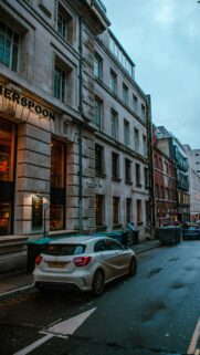 Urban Street Scene with Mercedes-Benz and Historic Architecture Wallpaper