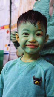 Cute Little Boy with Green Painted Face Holi Festival Mobile Wallpaper