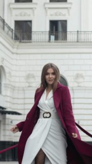 Elegant Woman in Burgundy Coat and White Dress Mobile Wallpaper