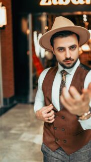 Elegant Gentleman in Brown Vest and Fedora Hat Mobile Wallpaper