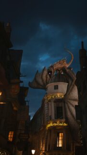 Epic Fantasy Dragon Perched Atop Gringotts Bank Mobile Wallpaper