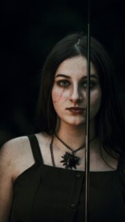 Dark Fantasy Witcher Girl with Sword and Wolf Medallion Wallpaper