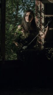 Mysterious Warrior Woman With Sword in Dark Forest Wallpaper