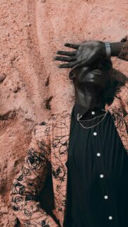 Stunning Fashion Portrait of a Man Resting on Sand Mobile Wallpaper