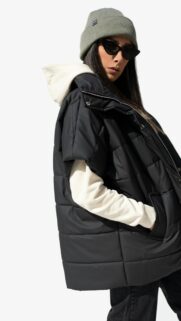 Stylish Woman in Black Puffer Vest and Beanie Mobile Wallpaper