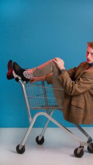 Stylish Man Sitting in Shopping Cart Aesthetic Portrait Wallpaper