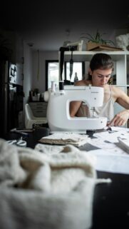 Focused Woman Sewing on a Singer Machine Lifestyle Mobile Wallpaper