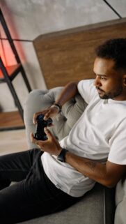 Gamer Man Sitting on Sofa Relaxing with Controller Mobile Wallpaper