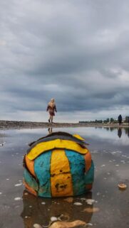 Melancholic Beach Scene with Abandoned Soccer Ball Phone Wallpaper