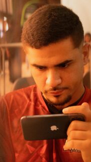 Focused Gamer Holding Smartphone Red Jersey Portrait Wallpaper