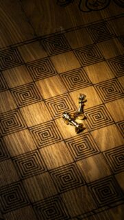 Golden King Chess Pieces on Rustic Wood Pattern Wallpaper