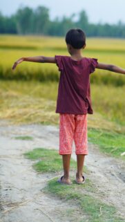 Child Standing in Rice Field Arms Outstretched Mobile Wallpaper