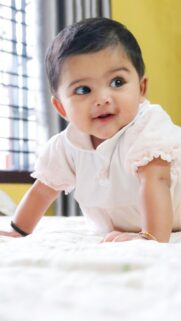 Adorable Baby Girl Smiling on Bed Mobile HD Wallpaper