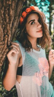 Boho Chic Girl With Flower Crown Under Trees Mobile Wallpaper