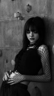 Gothic Aesthetic Girl Leaning Against Concrete Wall Phone Wallpaper