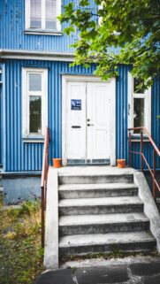 Blue Corrugated House Entrance with White Door Mobile Wallpaper