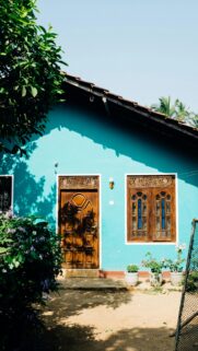 Turquoise Tropical House with Ornate Wood Doors and Windows Wallpaper