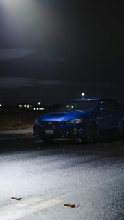Blue Subaru WRX Sport Sedan at Night on Wet Asphalt Mobile Wallpaper