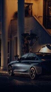 Stunning Luxury BMW Sedan Parked at a Grand Estate at Night Wallpaper