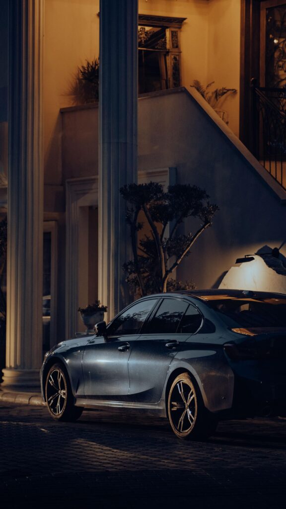 Stunning Luxury BMW Sedan Parked at a Grand Estate at Night Wallpaper