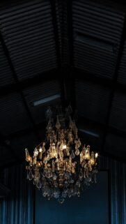 Elegant Crystal Chandelier Under Industrial Ceiling Mobile Wallpaper