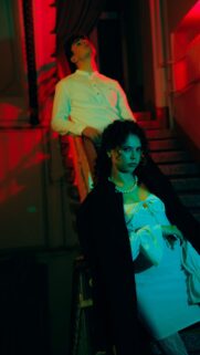 Stylish Couple in Cinematic Red and Teal Lighting Phone Wallpaper