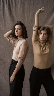 Two Fashionable Women in Beige Turtlenecks Elegant Portrait Wallpaper
