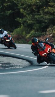 Sportbike Riders Speeding Through Sharp Curve Mobile Wallpaper