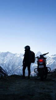 Motorcyclist Looking at Snow Mountains Mobile Wallpaper