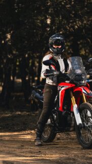 Adventurous Female Biker on Red Off-Road Motorcycle Wallpaper