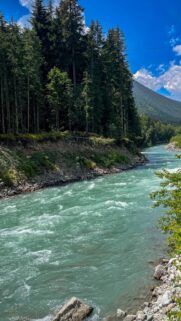 Stunning Turquoise Glacial River Through Alpine Forest Wallpaper