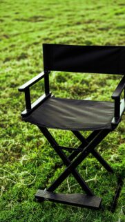 Minimalist Black Director Chair on Green Grass Mobile Wallpaper