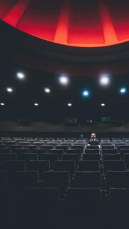 Solitary Man in Empty Red-Lit Cinema Phone Wallpaper