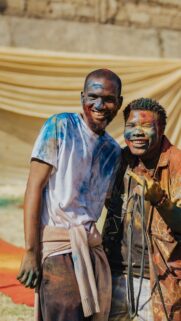 Joyful Friends Covered in Colorful Holi Powder Mobile Wallpaper