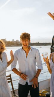 Friends Laughing on a Boat at Sunset Mobile Wallpaper