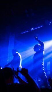 Electrifying Concert Silhouette with Blue Stage Lights Phone Wallpaper