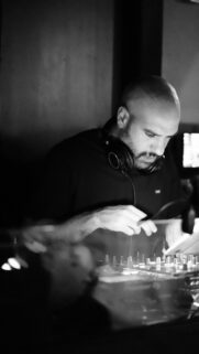 Professional DJ Mixing Music in Dim Club Light Mobile Wallpaper