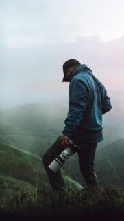 Photographer on Misty Mountain Peak Phone Wallpaper