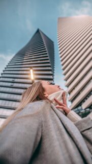 Woman Looking Up at Modern Skyscrapers in City Fashion Wallpaper