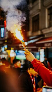Handheld Flare Burning in Night City Crowd High Quality Wallpaper