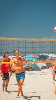 Professional Beach Volleyball Match Under Sunny Blue Skies Mobile Wallpaper