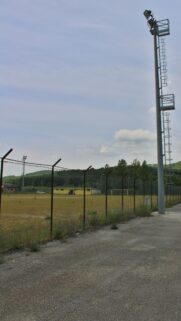 Industrial Stadium Floodlight and Fenced Field Mobile Wallpaper