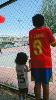 Two Brothers Watching Soccer Game at Field Mobile Wallpaper
