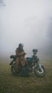 Lone Motorcyclist in Foggy Wilderness High-Quality Phone Wallpaper